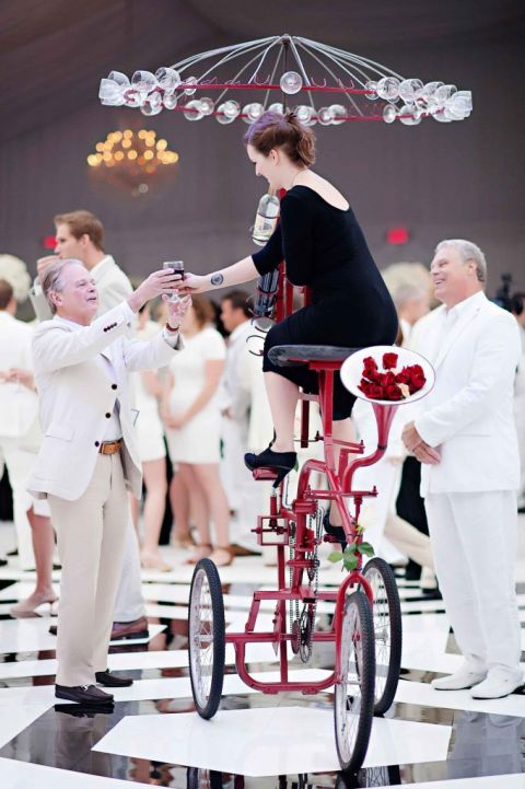 bicyclist entertaining guests, passing out champagne at a high end luxury wedding event design